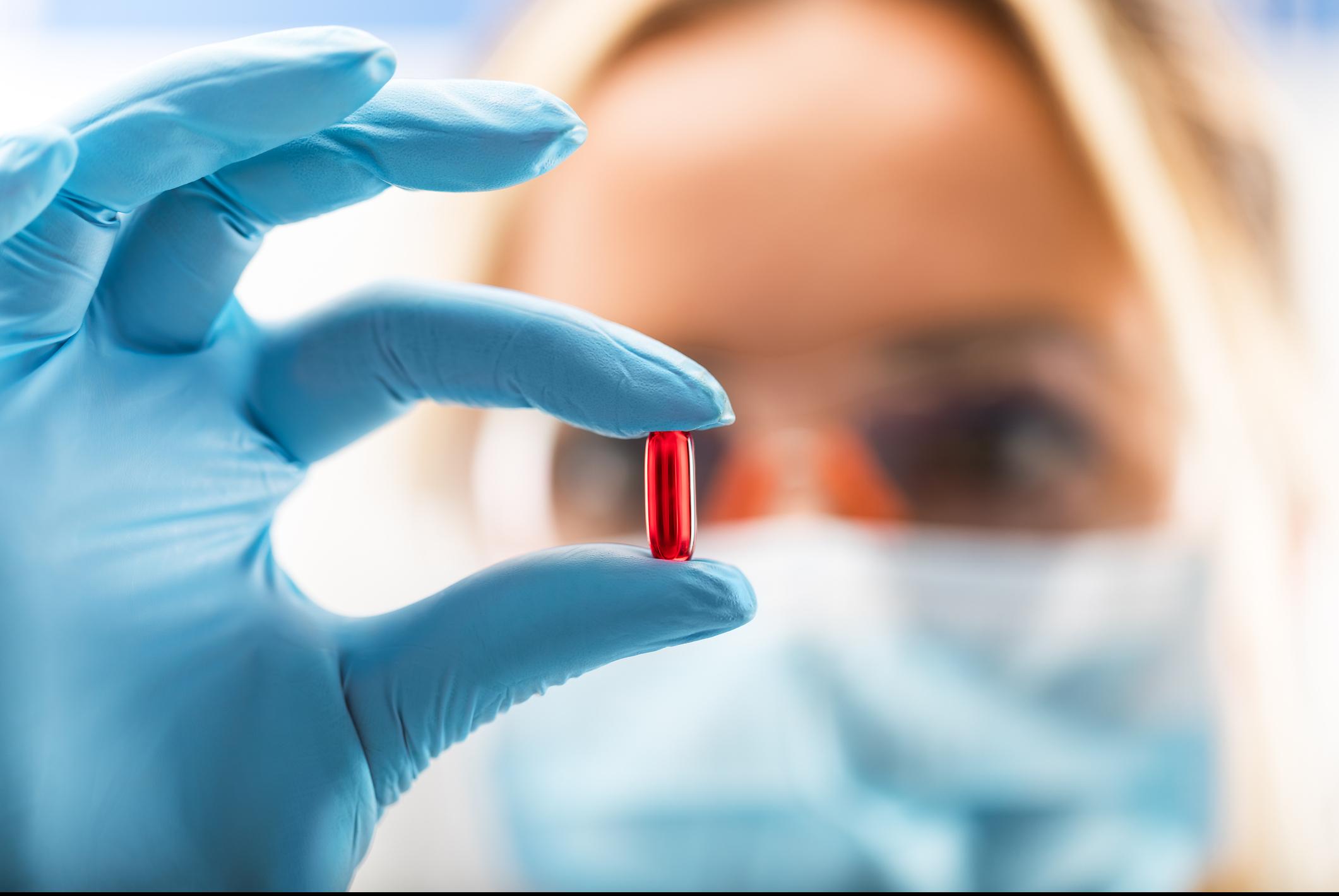 Woman holding pill.